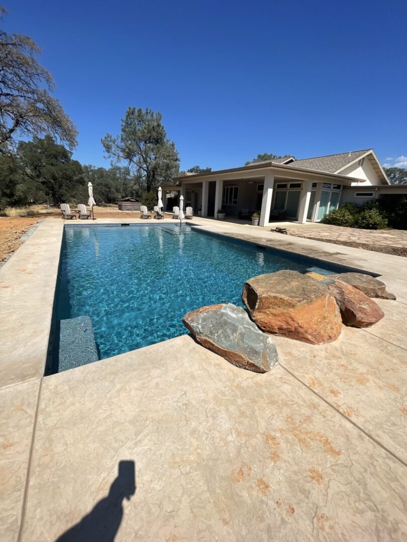 A swimming pool with four rocks in the side