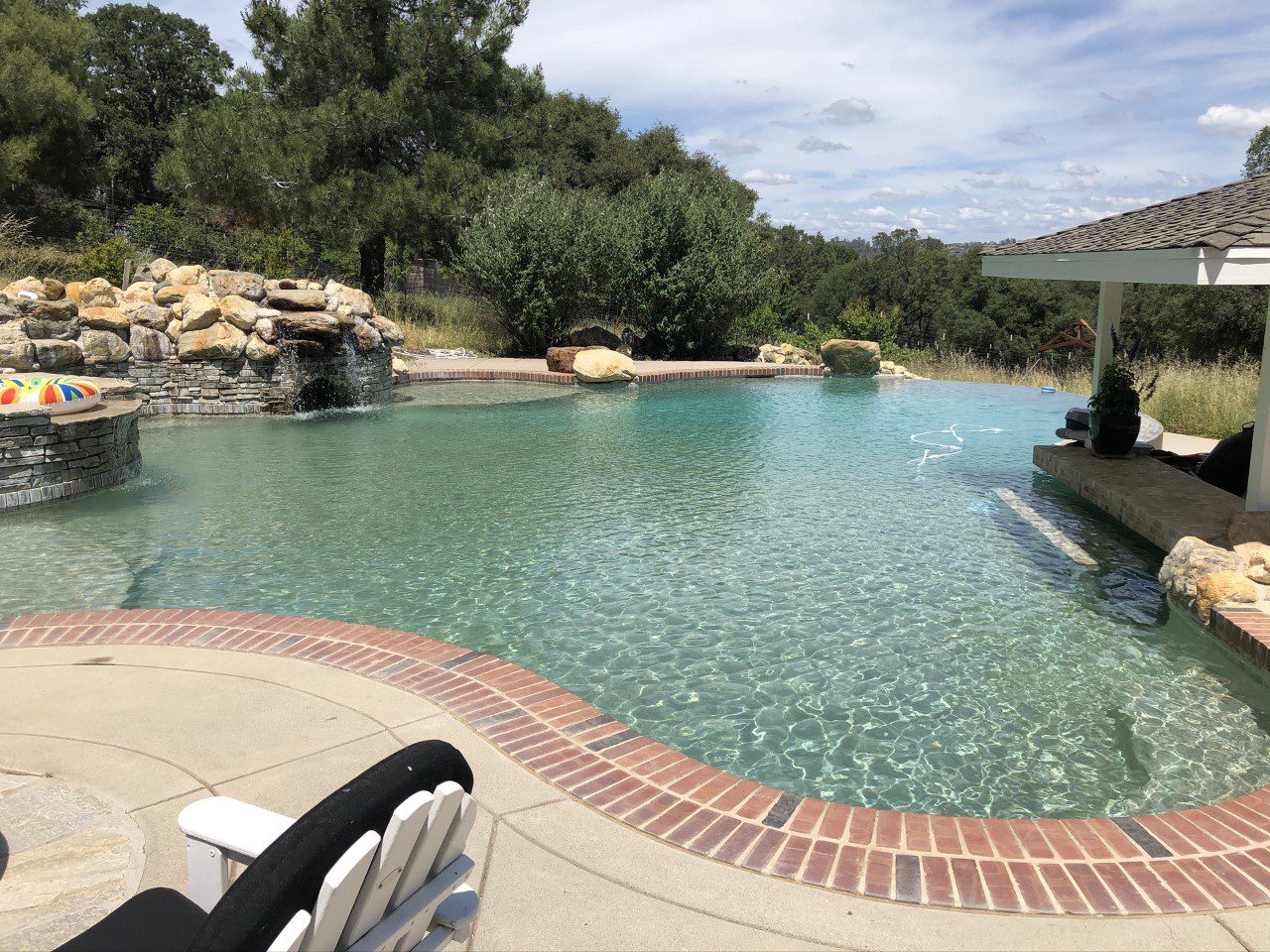 A huge swimming pool near a gazebo